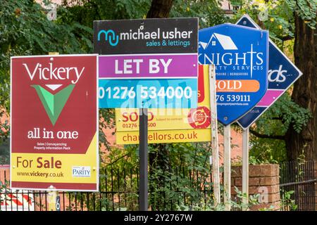 La fila di agenti immobiliari vende tavole all'esterno di appartamenti a Camberley, Surrey, Inghilterra, Regno Unito. Tema - mercato immobiliare, proprietà, agenti immobiliari, affitto, case Foto Stock