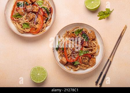 Tagliatelle Udon con tofu fritto e verdure guarnite con semi di sesamo Foto Stock