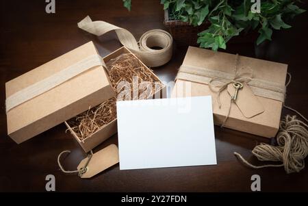 Scatole per imballaggio regalo con stringhe di iuta, carte vuote ed etichette con chiave piccola su superfici in legno pronte per il tuo branding. Foto Stock