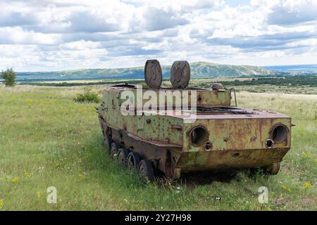 Rusty vecchio veicolo militare sovietico naufragato in un campo Foto Stock