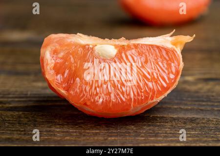 Pompelmo rosso maturo su un tavolo nero, pompelmo rosso succoso sbucciato Foto Stock