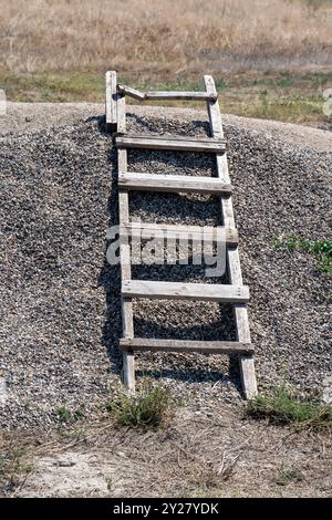 Antiche scale di legno nella sabbia: Luce e ombra in un giorno di sole. Foto Stock