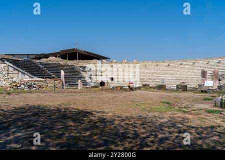 Anfiteatro dell'antica città macedone di Stobi (359 a.C.): Una prospettiva grandangolare sotto il cielo blu Foto Stock