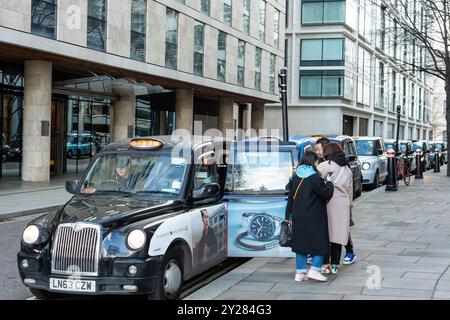 Fila di taxi di Londra in coda e in attesa di una tariffa presso il posteggio dei taxi di Lower Thames Street presso la Torre di Londra, Londra Inghilterra, Regno Unito Foto Stock