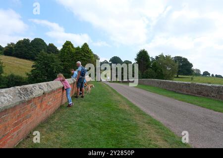 Persone che guardano sopra un vecchio muro di ponti Foto Stock