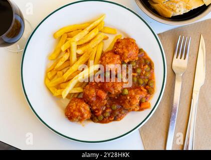 Polpette in stile giardino cotte con verdure servite con patatine fritte Foto Stock