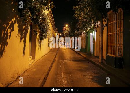 Strada vuota iluminata di notte con edifici coloniali a Cartagena, patrimonio mondiale dell'UNESCO Foto Stock