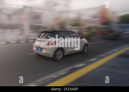 Balikpapan, Indonesia - 9 agosto 2024. Vista sul retro dell'auto elettrica Wuling Binguo, questa auto elettrica ecocompatibile scorre attraverso la strada della città Foto Stock
