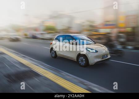 Balikpapan, Indonesia - 9 agosto 2024. Il movimento dinamico di questo veicolo elettrico e lo sfondo sfocato trasmettono un senso di velocità ed efficienza. Foto Stock