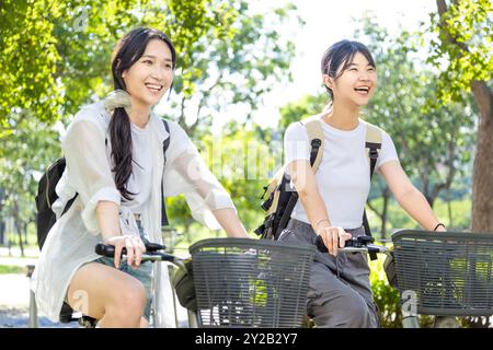 Ragazze felici che vanno in bicicletta e vanno a scuola Foto Stock