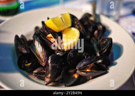 La Pepata, cozze locali del Golfo di Oristano, cotte al vapore con vino e servite con limone alla Pizza di Napule e’ Lago a Como, Italia Foto Stock