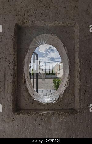 Una piccola finestra oblunga in un muro di pietra bianca di una scatola di sentinelle Foto Stock