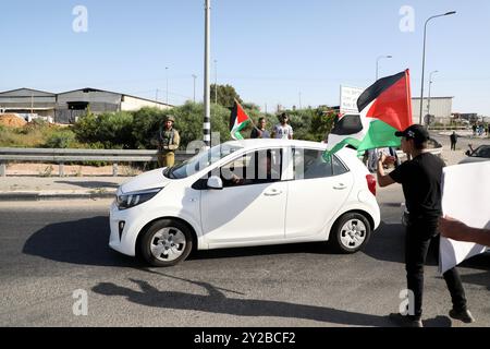 Qalqilya, Cisgiordania. Palestina. 9 giugno 2022. I palestinesi manifestano contro gli attacchi dei coloni nel villaggio della Cisgiordania di Izbat al-Tabib, nel governatorato di Qalqilya. I coloni israeliani sostenuti dai soldati israeliani hanno rinunciato alle bandiere israeliane vicino ai manifestanti palestinesi a Izbat al-Tabib, durante una delle loro incursioni nel villaggio. I palestinesi a Izbat al-Tabib sono stati separati da gran parte dei loro campi dal “muro di separazione della Cisgiordania”, hanno avuto terreni espropriati per la costruzione di una strada per un vicino insediamento israeliano, e sono costantemente esposti ad attacchi b Foto Stock