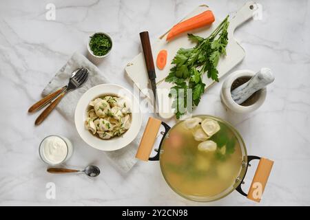 Vista dall'alto della carne pelmeni cucinata in brodo vegetale su un tavolo in marmo Foto Stock