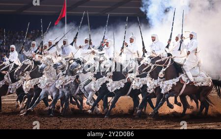 In Marocco, Fantasia risplende di colori vivaci e di splendide esposizioni. Cavalli maestosi e cavalieri valorosi, avvolti da abiti vivaci, si caricano in perfetta forma Foto Stock