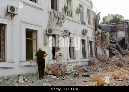 Gli uomini passano davanti all'edificio degli uffici dell'organizzazione umanitaria internazionale ACT Alliance distrutto da un attacco missilistico russo. La mattina presto, l'esercito russo lanciò un attacco missilistico combinato a Kiev, utilizzando più di 10 missili da crociera e circa 10 missili balistici di vario tipo. Frammenti di missili intercettati caddero nella maggior parte dei distretti della capitale, nei distretti di Sviatoshynskyi, Holosiivskyi e Shevchenkivskyi con conseguenze, causando distruzione o danni agli edifici e ai trasporti. Almeno tre persone sono rimaste ferite. Foto Stock