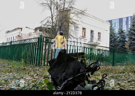 Un uomo guarda l'edificio degli uffici dell'organizzazione umanitaria internazionale ACT Alliance distrutto da un attacco missilistico russo. La mattina presto, l'esercito russo lanciò un attacco missilistico combinato a Kiev, utilizzando più di 10 missili da crociera e circa 10 missili balistici di vario tipo. Frammenti di missili intercettati caddero nella maggior parte dei distretti della capitale, nei distretti di Sviatoshynskyi, Holosiivskyi e Shevchenkivskyi con conseguenze, causando distruzione o danni agli edifici e ai trasporti. Almeno tre persone sono rimaste ferite. Foto Stock