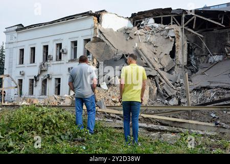 Gli uomini guardano all'edificio degli uffici dell'organizzazione umanitaria internazionale ACT Alliance distrutto da un attacco missilistico russo. La mattina presto, l'esercito russo lanciò un attacco missilistico combinato a Kiev, utilizzando più di 10 missili da crociera e circa 10 missili balistici di vario tipo. Frammenti di missili intercettati caddero nella maggior parte dei distretti della capitale, nei distretti di Sviatoshynskyi, Holosiivskyi e Shevchenkivskyi con conseguenze, causando distruzione o danni agli edifici e ai trasporti. Almeno tre persone sono rimaste ferite. Foto Stock