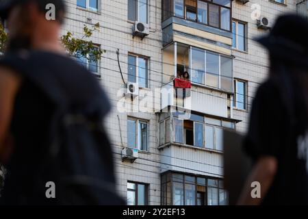 Bandiera nazionalista Ucraina in rosso e nero appeso fuori da una finestra durante la manifestazione pubblica a Kiev - 8 settembre 2024 Foto Stock