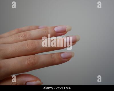 Chiodo rotto. Unghie lunghe naturali femminili da vicino. Manicure con chiodo incrinato. Foto Stock