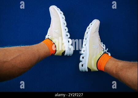 BERNA, SVIZZERA, 10 SETTEMBRE 2024: Le gambe di Pro Runner in Cloudflow 4 Super Shoes - le controverse calzature "illegali" evidenziate contro Blue Backdr Foto Stock