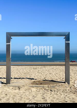 Knokke-Heist, Fiandre, Belgio - 24 giugno 2024: Installazione di una moderna doccia sulla spiaggia sabbiosa sotto il cielo blu, Sea in Back Foto Stock