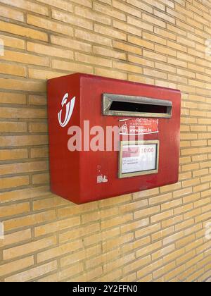 Knokke-Heist, Fiandre, Belgio - 24 giugno 2024: Primo piano della cassetta postale rossa sul muro di mattoni gialli Foto Stock