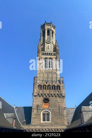 Bruges, Fiandre, Belgio - 25 giugno 2024: Belfry, Halletoren visto dal cortile interno contro il cielo blu Foto Stock