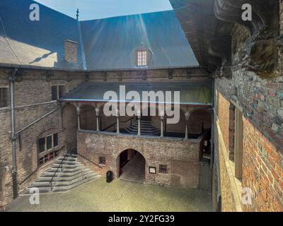 Bruges, Fiandre, Belgio - 25 giugno 2024: Halletoren e Belfry, scala coperta nel cortile interno Foto Stock