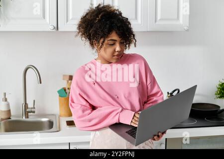 Si impegna con cura con il suo notebook in una cucina calda e invitante. Foto Stock