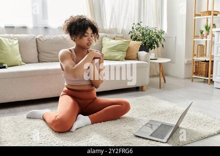 Una giovane donna ama trascorrere il proprio tempo a casa, seduto comodamente sul pavimento. Foto Stock