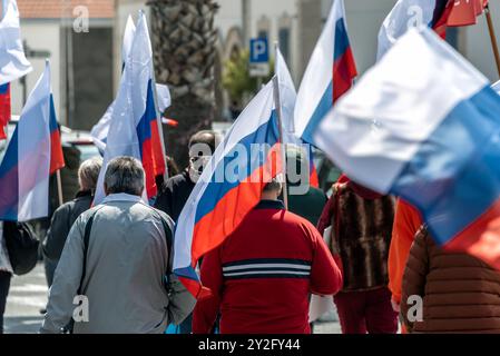 Larnaca, Cipro - 26 marzo 2022: Folla di persone che camminano per strada tenendo le bandiere russe durante il Rally Pro-Russo a Larnaca Foto Stock