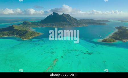 La splendida Bora Bora, con il suo iconico monte otemanu, le isole verdi e la laguna turchese, crea un'immagine di perfetto paradiso tropicale. Popolare destinazione turistica. Vista aerea sullo sfondo del viaggio con drone Foto Stock