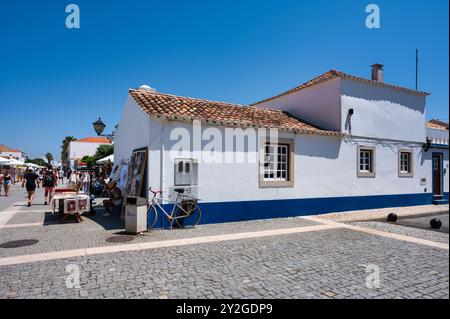 Porto Covo nell'alentejo Portogallo, affascinante strada acciottolata in un villaggio portoghese con case bianche. Foto Stock