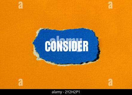Considerare il messaggio scritto su carta strappata arancione con sfondo blu. Simbolo concettuale da considerare. Copia spazio. Foto Stock