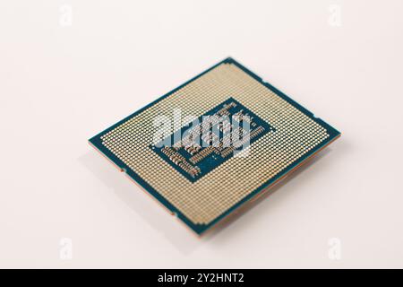 Primo piano del retro di un processore per computer con piedini, isolati su sfondo bianco Foto Stock