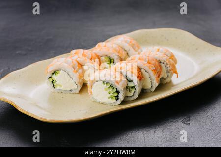 Involtini di sushi ai gamberi Philadelphia con ripieno cremoso e cetriolo, piatti della cucina giapponese Foto Stock