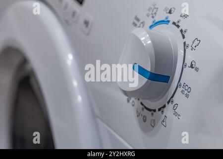 Selezione di programmi di lavaggio in una lavatrice, impostazione della lavatrice in modalità eco, risparmio di acqua ed energia Foto Stock