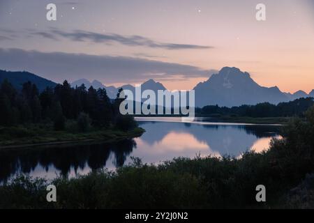 Un colorato bagliore di sera che splende con stelle sulle calme acque di Oxbow Bend. Grand Teton National Park, Wyoming Foto Stock