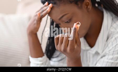 Oro anello di nozze in mano di sconvolgere nero donna Foto Stock