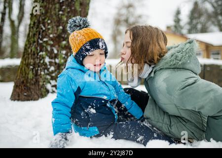 La sorella adolescente e il suo fratellino si divertono all'aperto. Ragazze con un bambino in inverno. Bambini con grande divario di età. Foto Stock