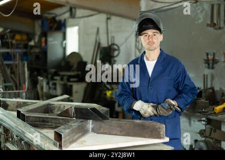 Durante la fabbricazione del prodotto, il dipendente MAN lavora con una saldatrice Foto Stock