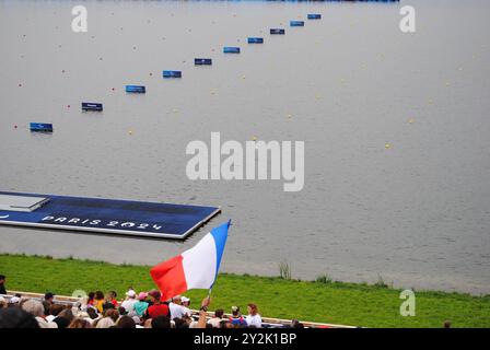 Vaires-sur-Marne, Francia - 07 settembre 2024: Bandiere francesi sventolate dagli spettatori allo Stadio Nautico Vaires-Sur-Marne durante i Giochi Paralimpici di Parigi 2024. Foto Stock