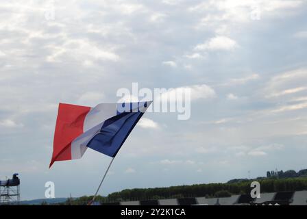 Vaires-sur-Marne, Francia - 07 settembre 2024: Bandiere francesi sventolate dagli spettatori allo Stadio Nautico Vaires-Sur-Marne durante i Giochi Paralimpici di Parigi 2024. Foto Stock