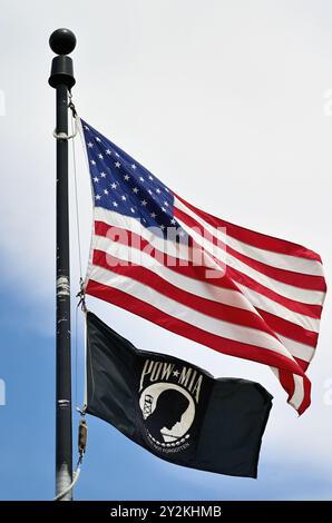 Carol Stream, Illinois, Stati Uniti. Le bandiere americane e POW/mia sfrecciano in una brezza in un monumento commemorativo ai veterani. Foto Stock