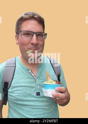 Uomo che mangia gelato con gioia Foto Stock