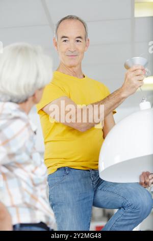 coppia senior che passa a una lampadina più efficiente Foto Stock