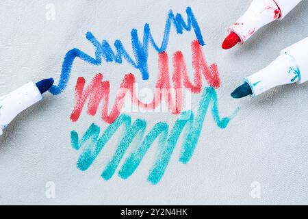 Un bambino disegna a mano penne in feltro sui mobili imbottiti bianchi del divano o su un tappeto. vista dall'alto. Macchia sporca per il concetto di pulizia. Alta qualita' Foto Stock