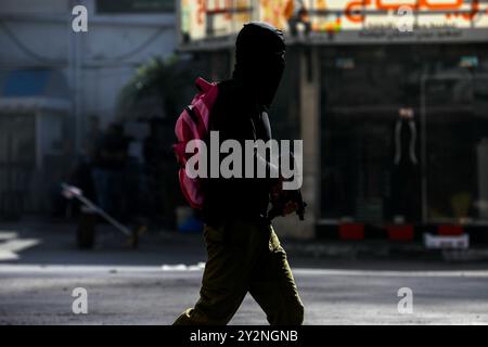 Jenin, Cisgiordania, Palestina. 9 novembre 2023. I militanti palestinesi si scontrano con l'esercito israeliano nel campo profughi di Jenin, a seguito di un raid israeliano su Jenin, nella Cisgiordania settentrionale, avvenuto giovedì. Il bilancio delle vittime a Jenin è attualmente di 8 palestinesi, con almeno altri 14 feriti nel raid israeliano in corso. Le forze israeliane sono state intensificate incursioni in Cisgiordania dall'inizio della guerra a Gaza Foto Stock