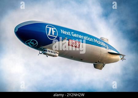 Zeppelin über dem Bodensee, Werbeslogan ZF Next Generation Mobility Now, Überlingen, settembre 2024 Deutschland, Überlingen, settembre 2024, Zeppelin über dem Bodensee, Werbeslogan ZF Next Generation Mobility Now, ZF Friedrichshafen AG im Moment unter Druck wegen Stellenabbau, Zeppelin NT, Flug, ein Zeppelinflug kostet 330 Euro für 30 Minuten, Zeppelin fliegt in 300 Metern Höhe, sind 75 Meter lang, Luftverkehr, Luftschiff, Tourismus, Baden-Württemberg *** Zeppelin sul lago di Costanza, slogan pubblicitario ZF Next Generation Mobility Now, Überlingen, settembre 2024 Germania, Überlingen, settembre Foto Stock